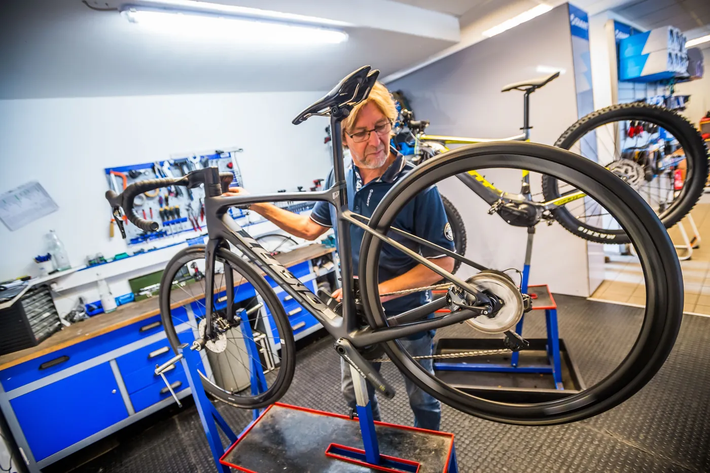 Mechaniker bei der Reparatur eines Mountainbikes auf dem Montageständer in der Werkstatt von Fahrrad Hesse